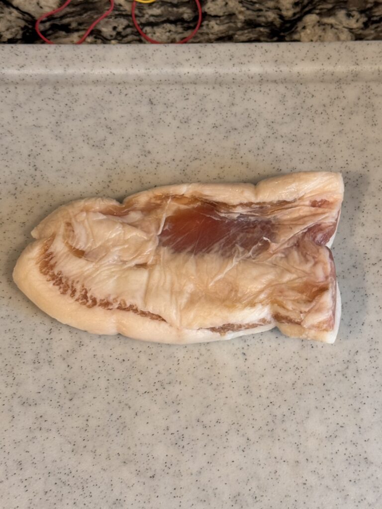 グアンチャーレ作成用の豚トロにピチットシートを巻いている写真