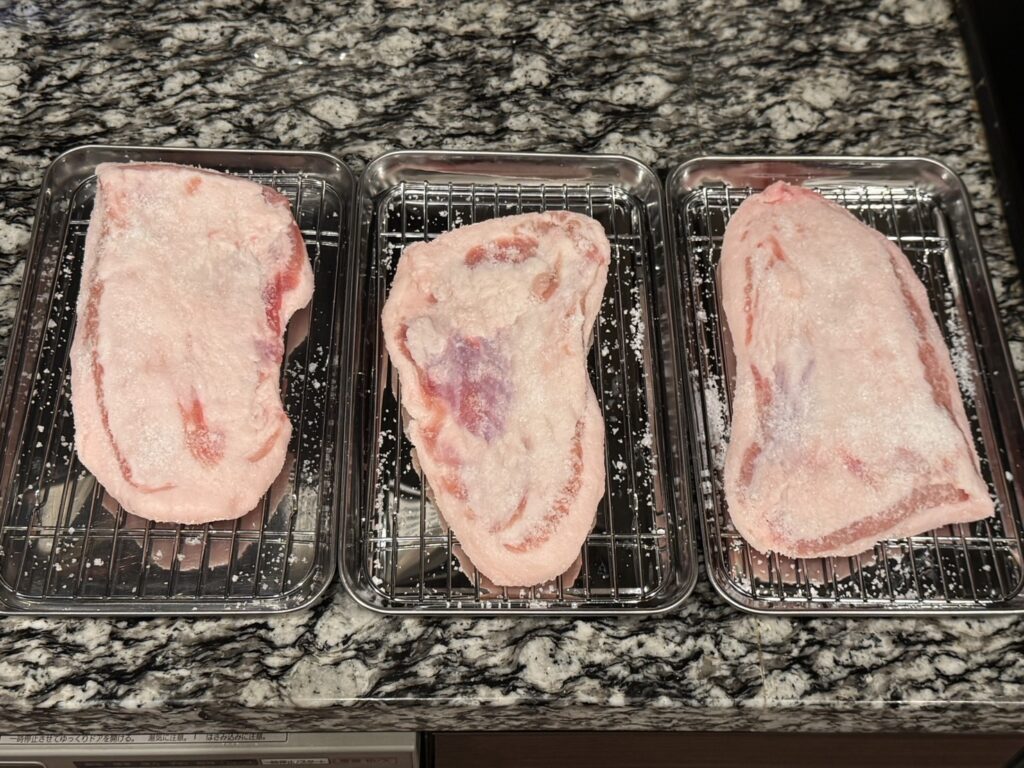グアンチャーレ作成用の豚トロに塩をまぶしている写真