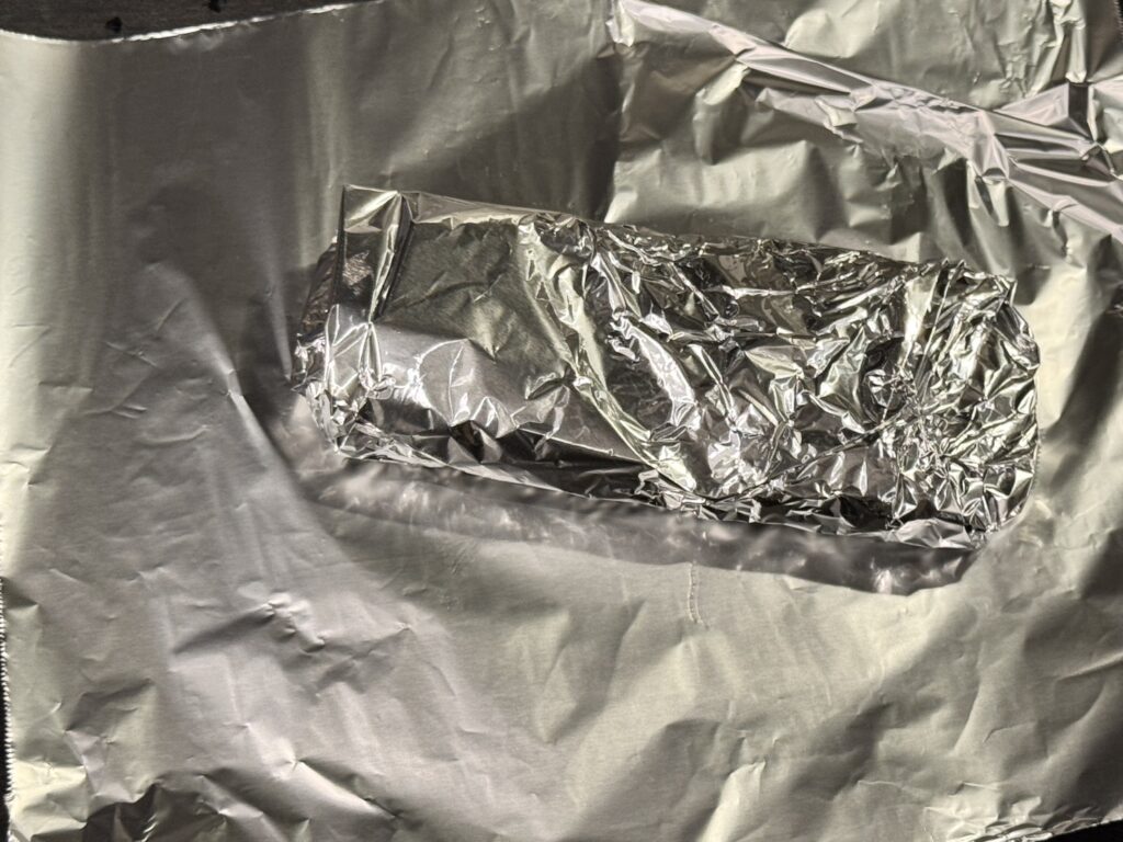 焼き上がってアルミホイルに包まれているステーキ