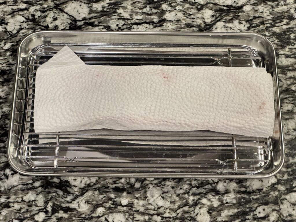 キッチンペーパーでドリップを拭いているオーケーストアで購入したグラム369円のオージービーフ