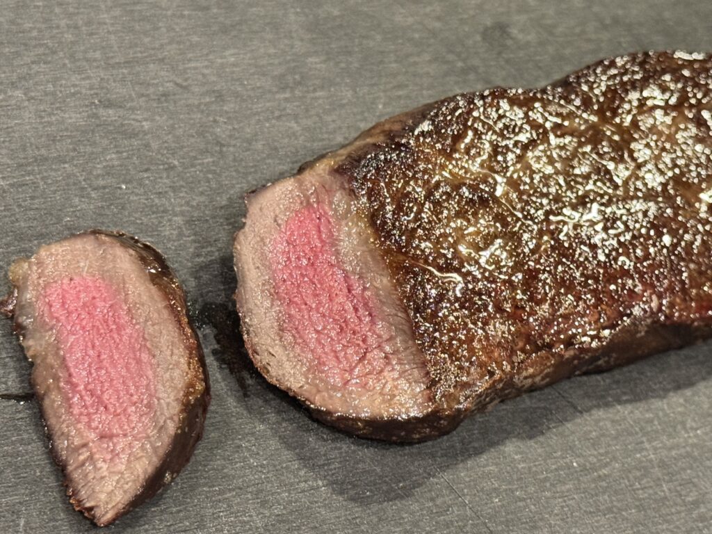 厚切り牛ステーキのミディアムレアな焼き加減。外はカリッと中はピンク色のジューシーな仕上がり。