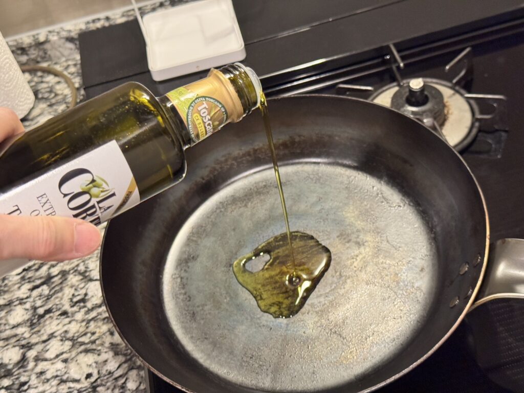 山田工業所の鉄フライパンにオリーブオイルを垂らしている写真