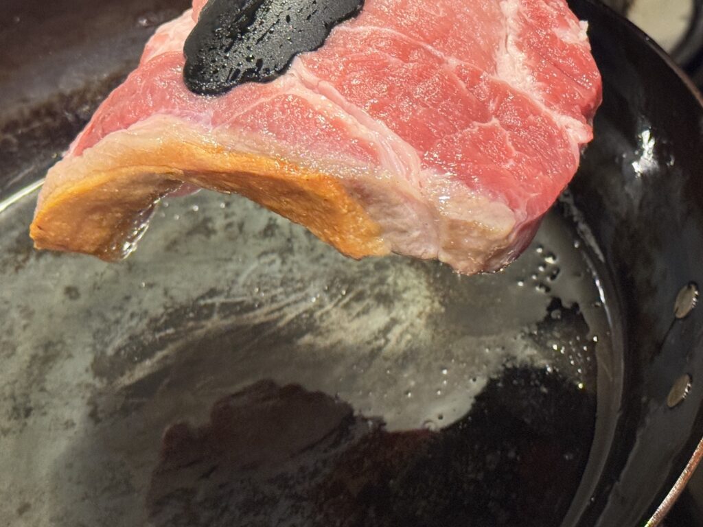 山田工業所の鉄フライパンで豚肉の脂身が焼けた状態