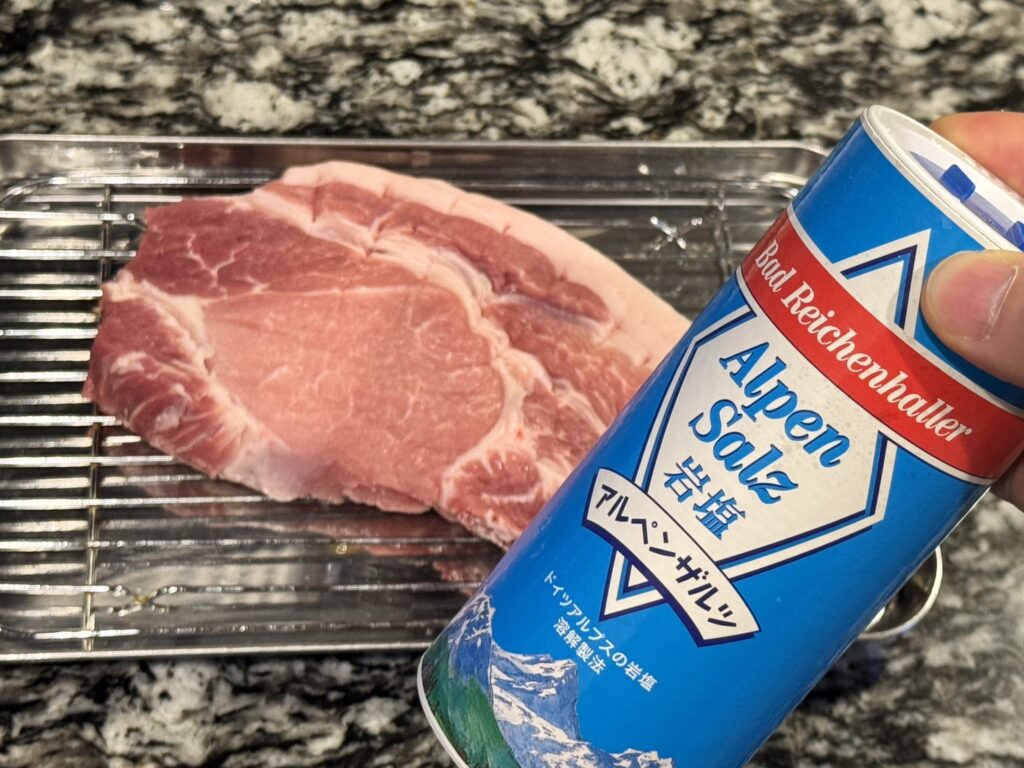 筋を切った豚肉にアルペンザルツの塩をかける写真